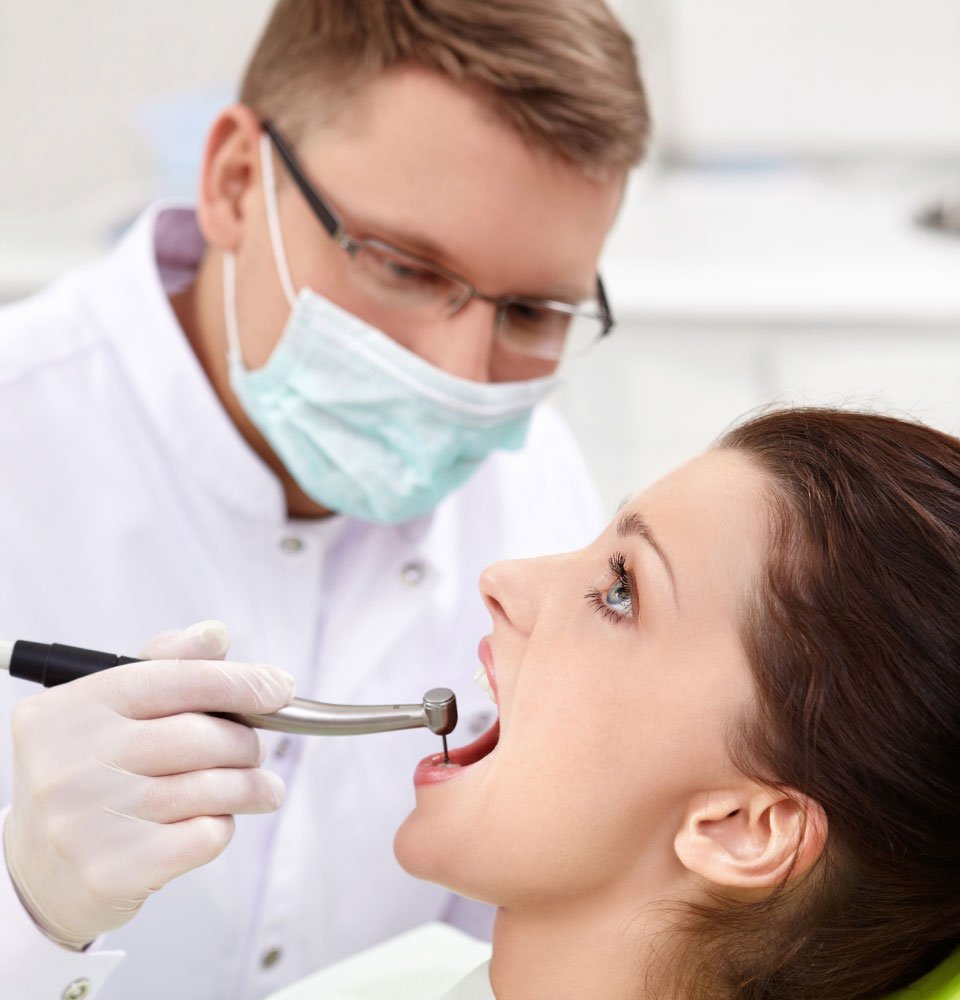 Dentist examining a patient's teeth during a dental checkup.