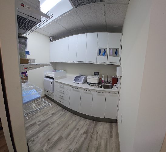 Modern white kitchen with curved cabinetry and wood flooring.