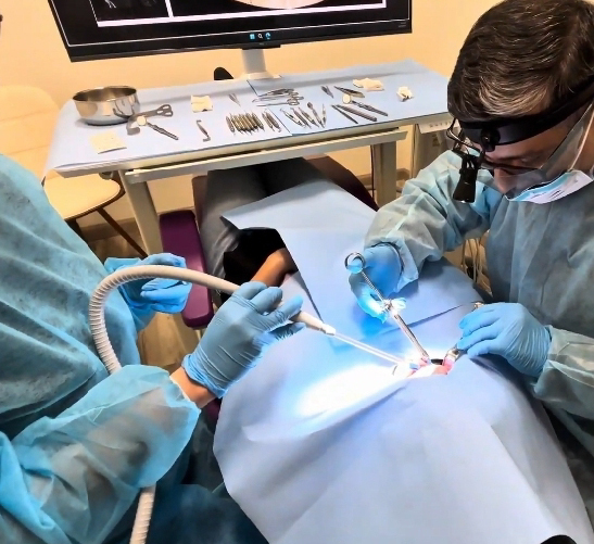 Dentists performing a dental procedure on a patient.